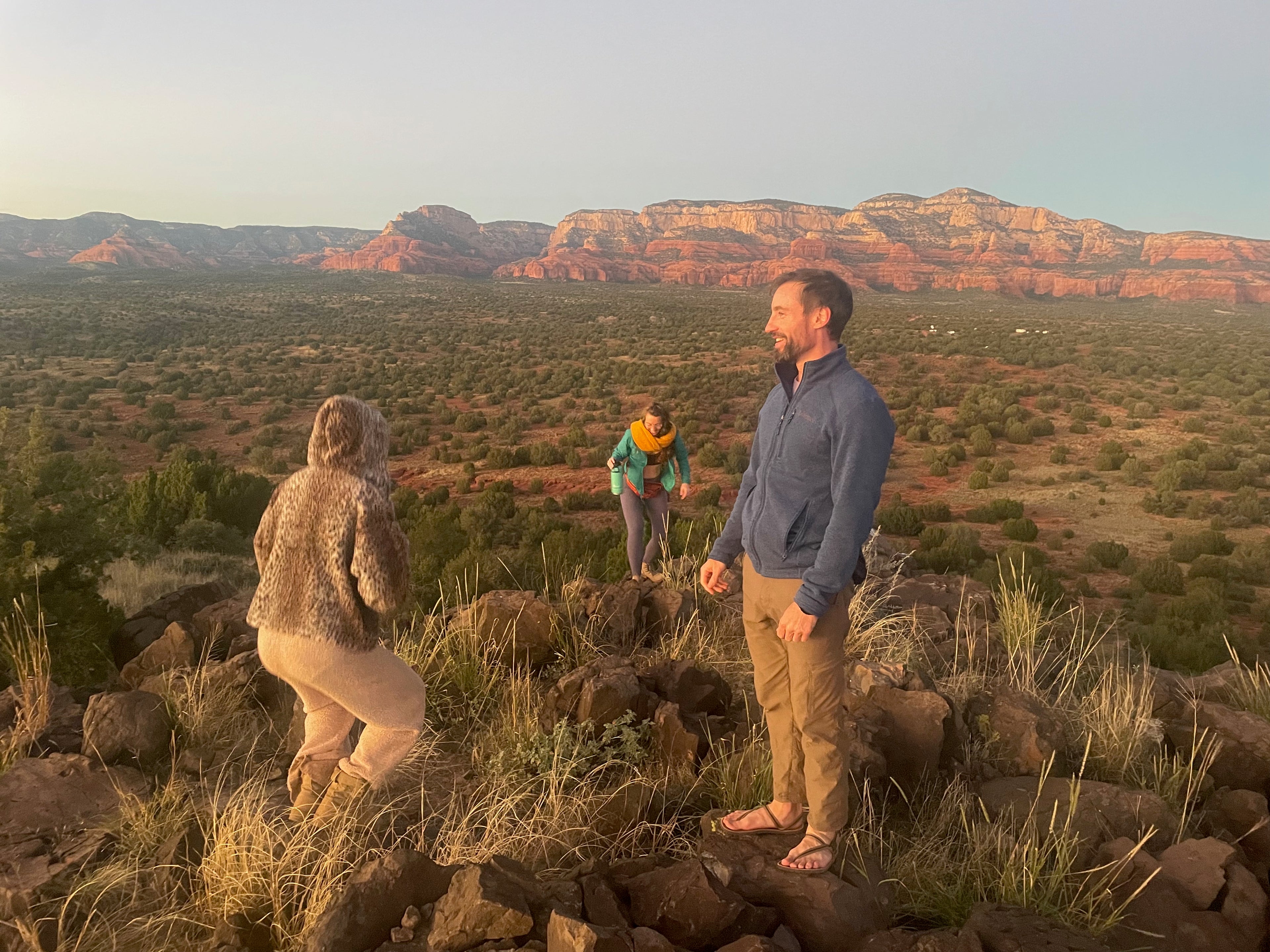 Group of people hiking in Sedona, surrounded by red rock formations and natural beauty, emphasizing mindfulness, connection, and outdoor exploration.